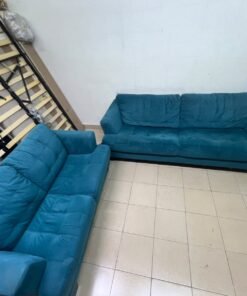 A velvet sofa set in a teal (blue-green) color, consisting of a two-seater sofa and a larger three-seater sofa.
