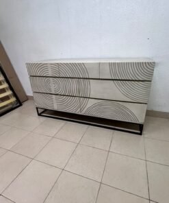 A chest of drawers featuring a geometric design with raised circular patterns—known as the 7-drawer "Circulus" chest from Crate & Barrel, or a very similar design from the "Gerald" collection by Home Centre.