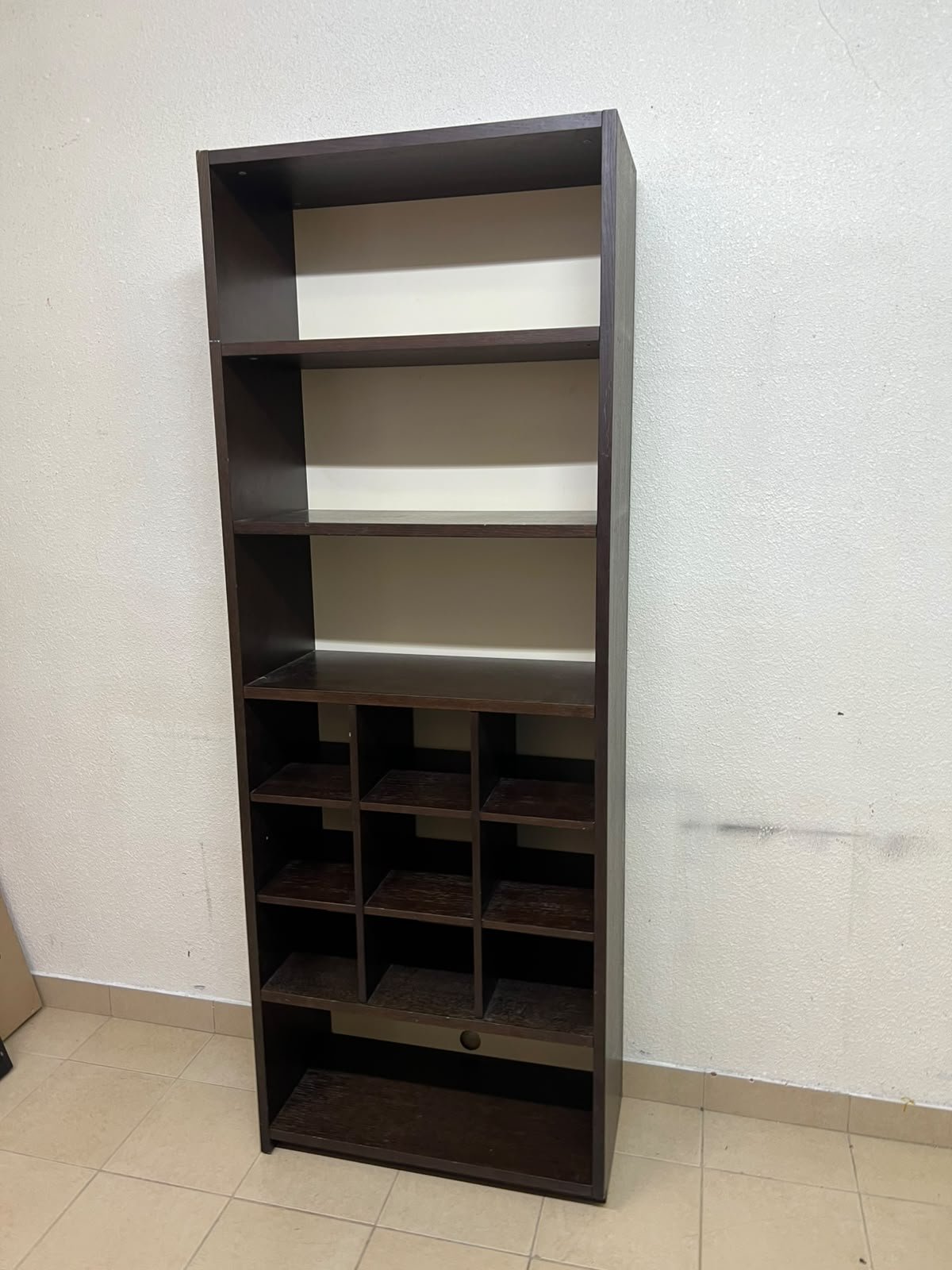 A tall, dark brown (black-brown or wenge-colored) wooden storage unit, featuring open shelves at the top and 12 small compartments (storage squares) in the lower section.