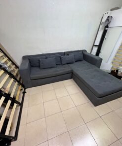 A dark gray L-shaped sectional sofa with a modern design, featuring a long chaise lounge, a tufted seat cushion, and additional back cushions. - Image 10