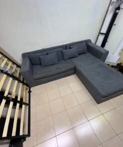 A dark gray L-shaped sectional sofa with a modern design, featuring a long chaise lounge, a tufted seat cushion, and additional back cushions. - Image 11