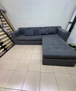 A dark gray L-shaped sectional sofa with a modern design, featuring a long chaise lounge, a tufted seat cushion, and additional back cushions. - Image 6