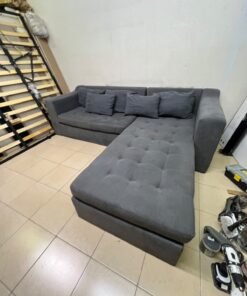 A dark gray L-shaped sectional sofa with a modern design, featuring a long chaise lounge, a tufted seat cushion, and additional back cushions. - Image 7
