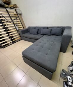 A dark gray L-shaped sectional sofa with a modern design, featuring a long chaise lounge, a tufted seat cushion, and additional back cushions. - Image 8
