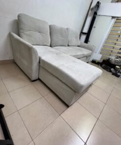 # Convertible Fabric Corner Sofa Bed with Chaise Longue and Storage – Home Box UAE Upgrade your living room with this practical and stylish convertible fabric corner sofa bed from Home Box UAE, designed to combine comfort, functionality, and modern elegance in one versatile piece of furniture. Featuring a spacious three-seater design with an extended chaise longue, this sofa provides plenty of room for relaxing, watching television, entertaining guests, or spending quality time with family. Its attractive fabric upholstery adds a warm and welcoming touch to any living space, making it an excellent choice for apartments, villas, guest rooms, and modern homes. One of the main advantages of this corner sofa is its convertible sofa-bed function, which allows you to transform the seating area into a comfortable sleeping space whenever needed. This practical feature makes it especially suitable for homes where extra sleeping arrangements are occasionally required without sacrificing valuable floor space. Whether you have overnight visitors or simply want a comfortable place to stretch out and relax, this multifunctional design offers flexibility for everyday living. The extended chaise longue provides additional legroom, allowing you to sit back comfortably, read a book, enjoy your favourite shows, or take a relaxing afternoon nap. The spacious seating arrangement makes it suitable for individuals, couples, and families looking for furniture that offers both convenience and comfort. Another useful feature is the integrated storage compartment, which provides extra room for keeping blankets, pillows, bedsheets, cushions, and other household essentials neatly organised and within easy reach. With its combination of seating, sleeping, and storage functions, this fabric corner sofa is an excellent space-saving solution for contemporary interiors. Its versatile design allows it to serve as the main sofa in a living room while also functioning as a guest bed and a convenient storage unit. The fabric finish complements a variety of interior styles, including modern, minimalist, contemporary, and casual home décor, making it easy to incorporate into different living environments. If you are searching for an affordable and functional sofa bed in Dubai, Sharjah, or Ajman, this Home Box-style convertible corner sofa is worth considering for its practical features and versatile use. It is particularly suitable for people furnishing a new apartment, upgrading their existing living room, or looking for multifunctional furniture that makes the most of available space. At Yahya Used Furniture, we offer a wide selection of second-hand furniture for customers looking for practical home furnishing solutions at affordable prices. If you are interested in buying a used corner sofa, sofa bed, chaise longue, or other living room furniture, explore our available collection to discover options that suit your space and budget. Choose a sofa that brings together comfortable seating, flexible sleeping arrangements, and useful storage in one convenient design. This convertible fabric corner sofa bed is a practical furniture choice for making your living room more comfortable, organised, and ready for everyday life. - Image 5