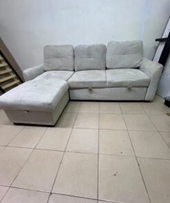 # Convertible Fabric Corner Sofa Bed with Chaise Longue and Storage – Home Box UAE Upgrade your living room with this practical and stylish convertible fabric corner sofa bed from Home Box UAE, designed to combine comfort, functionality, and modern elegance in one versatile piece of furniture. Featuring a spacious three-seater design with an extended chaise longue, this sofa provides plenty of room for relaxing, watching television, entertaining guests, or spending quality time with family. Its attractive fabric upholstery adds a warm and welcoming touch to any living space, making it an excellent choice for apartments, villas, guest rooms, and modern homes. One of the main advantages of this corner sofa is its convertible sofa-bed function, which allows you to transform the seating area into a comfortable sleeping space whenever needed. This practical feature makes it especially suitable for homes where extra sleeping arrangements are occasionally required without sacrificing valuable floor space. Whether you have overnight visitors or simply want a comfortable place to stretch out and relax, this multifunctional design offers flexibility for everyday living. The extended chaise longue provides additional legroom, allowing you to sit back comfortably, read a book, enjoy your favourite shows, or take a relaxing afternoon nap. The spacious seating arrangement makes it suitable for individuals, couples, and families looking for furniture that offers both convenience and comfort. Another useful feature is the integrated storage compartment, which provides extra room for keeping blankets, pillows, bedsheets, cushions, and other household essentials neatly organised and within easy reach. With its combination of seating, sleeping, and storage functions, this fabric corner sofa is an excellent space-saving solution for contemporary interiors. Its versatile design allows it to serve as the main sofa in a living room while also functioning as a guest bed and a convenient storage unit. The fabric finish complements a variety of interior styles, including modern, minimalist, contemporary, and casual home décor, making it easy to incorporate into different living environments. If you are searching for an affordable and functional sofa bed in Dubai, Sharjah, or Ajman, this Home Box-style convertible corner sofa is worth considering for its practical features and versatile use. It is particularly suitable for people furnishing a new apartment, upgrading their existing living room, or looking for multifunctional furniture that makes the most of available space. At Yahya Used Furniture, we offer a wide selection of second-hand furniture for customers looking for practical home furnishing solutions at affordable prices. If you are interested in buying a used corner sofa, sofa bed, chaise longue, or other living room furniture, explore our available collection to discover options that suit your space and budget. Choose a sofa that brings together comfortable seating, flexible sleeping arrangements, and useful storage in one convenient design. This convertible fabric corner sofa bed is a practical furniture choice for making your living room more comfortable, organised, and ready for everyday life. - Image 7