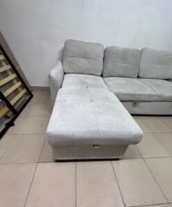 # Convertible Fabric Corner Sofa Bed with Chaise Longue and Storage – Home Box UAE Upgrade your living room with this practical and stylish convertible fabric corner sofa bed from Home Box UAE, designed to combine comfort, functionality, and modern elegance in one versatile piece of furniture. Featuring a spacious three-seater design with an extended chaise longue, this sofa provides plenty of room for relaxing, watching television, entertaining guests, or spending quality time with family. Its attractive fabric upholstery adds a warm and welcoming touch to any living space, making it an excellent choice for apartments, villas, guest rooms, and modern homes. One of the main advantages of this corner sofa is its convertible sofa-bed function, which allows you to transform the seating area into a comfortable sleeping space whenever needed. This practical feature makes it especially suitable for homes where extra sleeping arrangements are occasionally required without sacrificing valuable floor space. Whether you have overnight visitors or simply want a comfortable place to stretch out and relax, this multifunctional design offers flexibility for everyday living. The extended chaise longue provides additional legroom, allowing you to sit back comfortably, read a book, enjoy your favourite shows, or take a relaxing afternoon nap. The spacious seating arrangement makes it suitable for individuals, couples, and families looking for furniture that offers both convenience and comfort. Another useful feature is the integrated storage compartment, which provides extra room for keeping blankets, pillows, bedsheets, cushions, and other household essentials neatly organised and within easy reach. With its combination of seating, sleeping, and storage functions, this fabric corner sofa is an excellent space-saving solution for contemporary interiors. Its versatile design allows it to serve as the main sofa in a living room while also functioning as a guest bed and a convenient storage unit. The fabric finish complements a variety of interior styles, including modern, minimalist, contemporary, and casual home décor, making it easy to incorporate into different living environments. If you are searching for an affordable and functional sofa bed in Dubai, Sharjah, or Ajman, this Home Box-style convertible corner sofa is worth considering for its practical features and versatile use. It is particularly suitable for people furnishing a new apartment, upgrading their existing living room, or looking for multifunctional furniture that makes the most of available space. At Yahya Used Furniture, we offer a wide selection of second-hand furniture for customers looking for practical home furnishing solutions at affordable prices. If you are interested in buying a used corner sofa, sofa bed, chaise longue, or other living room furniture, explore our available collection to discover options that suit your space and budget. Choose a sofa that brings together comfortable seating, flexible sleeping arrangements, and useful storage in one convenient design. This convertible fabric corner sofa bed is a practical furniture choice for making your living room more comfortable, organised, and ready for everyday life. - Image 8