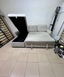 # Convertible Fabric Corner Sofa Bed with Chaise Longue and Storage – Home Box UAE Upgrade your living room with this practical and stylish convertible fabric corner sofa bed from Home Box UAE, designed to combine comfort, functionality, and modern elegance in one versatile piece of furniture. Featuring a spacious three-seater design with an extended chaise longue, this sofa provides plenty of room for relaxing, watching television, entertaining guests, or spending quality time with family. Its attractive fabric upholstery adds a warm and welcoming touch to any living space, making it an excellent choice for apartments, villas, guest rooms, and modern homes. One of the main advantages of this corner sofa is its convertible sofa-bed function, which allows you to transform the seating area into a comfortable sleeping space whenever needed. This practical feature makes it especially suitable for homes where extra sleeping arrangements are occasionally required without sacrificing valuable floor space. Whether you have overnight visitors or simply want a comfortable place to stretch out and relax, this multifunctional design offers flexibility for everyday living. The extended chaise longue provides additional legroom, allowing you to sit back comfortably, read a book, enjoy your favourite shows, or take a relaxing afternoon nap. The spacious seating arrangement makes it suitable for individuals, couples, and families looking for furniture that offers both convenience and comfort. Another useful feature is the integrated storage compartment, which provides extra room for keeping blankets, pillows, bedsheets, cushions, and other household essentials neatly organised and within easy reach. With its combination of seating, sleeping, and storage functions, this fabric corner sofa is an excellent space-saving solution for contemporary interiors. Its versatile design allows it to serve as the main sofa in a living room while also functioning as a guest bed and a convenient storage unit. The fabric finish complements a variety of interior styles, including modern, minimalist, contemporary, and casual home décor, making it easy to incorporate into different living environments. If you are searching for an affordable and functional sofa bed in Dubai, Sharjah, or Ajman, this Home Box-style convertible corner sofa is worth considering for its practical features and versatile use. It is particularly suitable for people furnishing a new apartment, upgrading their existing living room, or looking for multifunctional furniture that makes the most of available space. At Yahya Used Furniture, we offer a wide selection of second-hand furniture for customers looking for practical home furnishing solutions at affordable prices. If you are interested in buying a used corner sofa, sofa bed, chaise longue, or other living room furniture, explore our available collection to discover options that suit your space and budget. Choose a sofa that brings together comfortable seating, flexible sleeping arrangements, and useful storage in one convenient design. This convertible fabric corner sofa bed is a practical furniture choice for making your living room more comfortable, organised, and ready for everyday life. - Image 11
