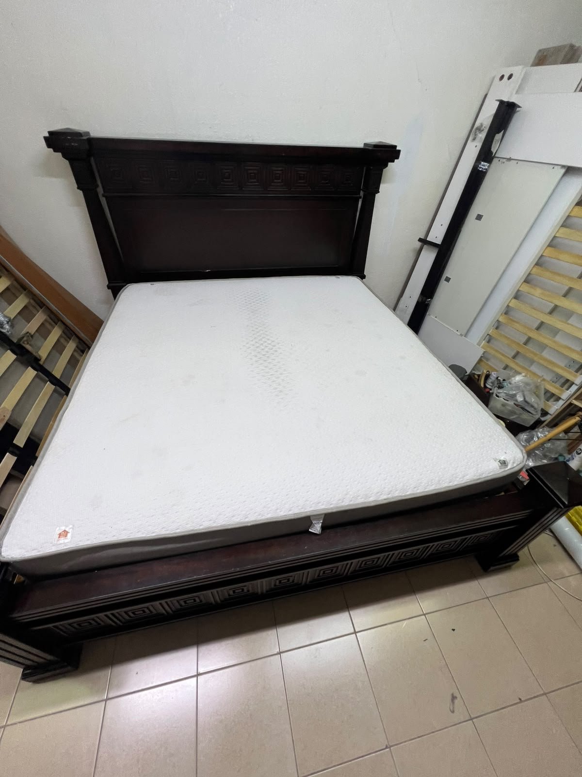 Large, classic double bed (king-size) with mattress, crafted from dark wood and featuring a headboard and footboard adorned with square-patterned detailing. - Image 3