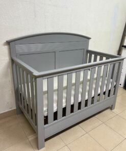 A convertible crib (such as the Serta Barrett model or the Dylan crib by Juniors, available at Centrepoint UAE) in an elegant gray color, featuring a classic, adjustable design that adapts to the various stages of a child's growth. - Image 7