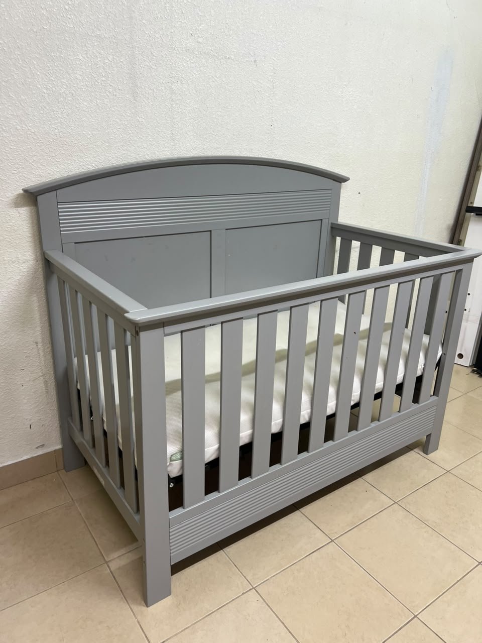 A convertible crib (such as the Serta Barrett model or the Dylan crib by Juniors, available at Centrepoint UAE) in an elegant gray color, featuring a classic, adjustable design that adapts to the various stages of a child's growth. - Image 7