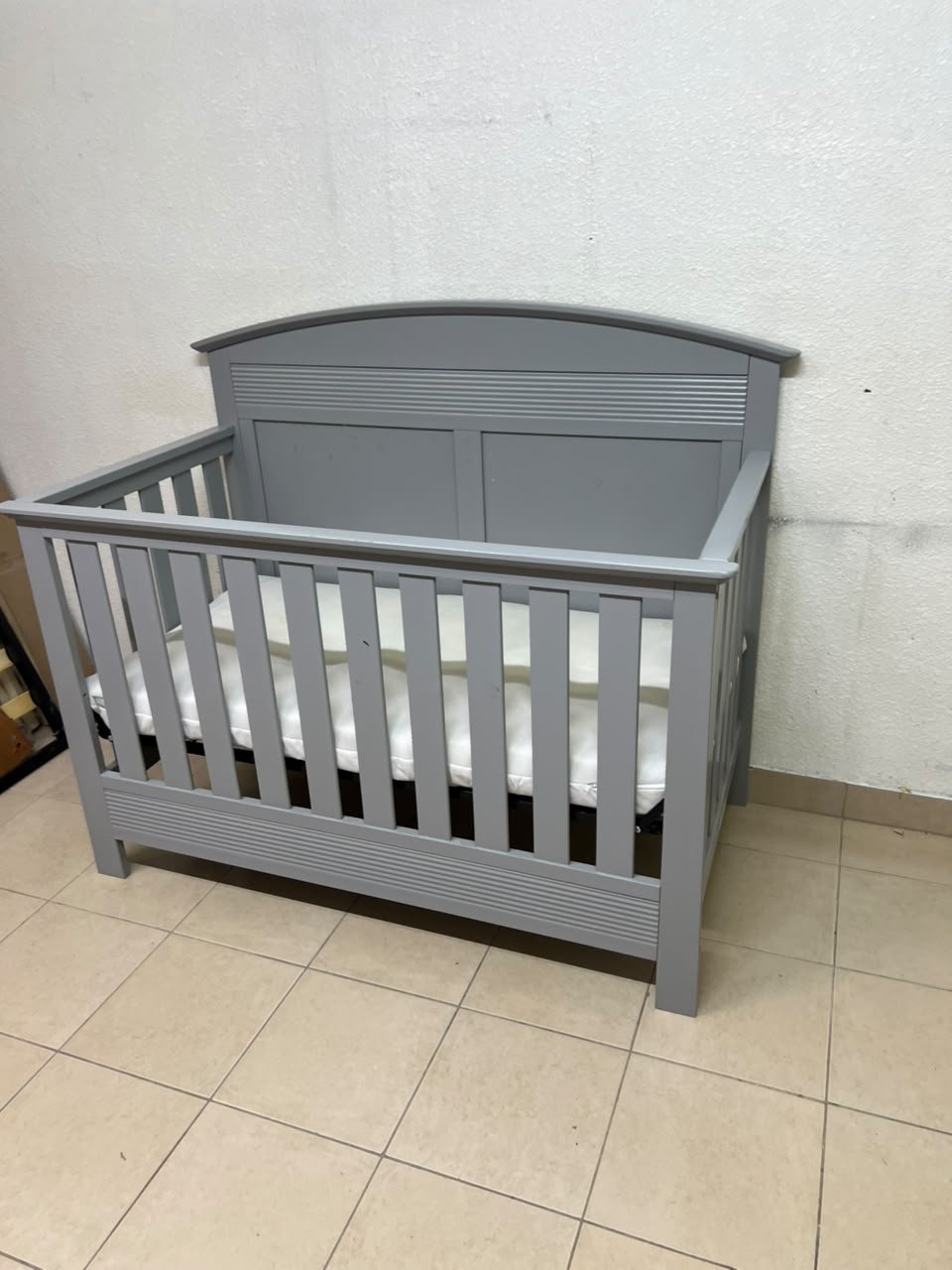 A convertible crib (such as the Serta Barrett model or the Dylan crib by Juniors, available at Centrepoint UAE) in an elegant gray color, featuring a classic, adjustable design that adapts to the various stages of a child's growth. - Image 8
