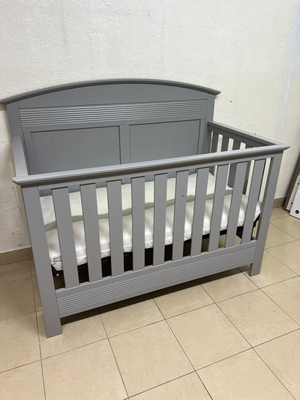 A convertible crib (such as the Serta Barrett model or the Dylan crib by Juniors, available at Centrepoint UAE) in an elegant gray color, featuring a classic, adjustable design that adapts to the various stages of a child's growth. - Image 10