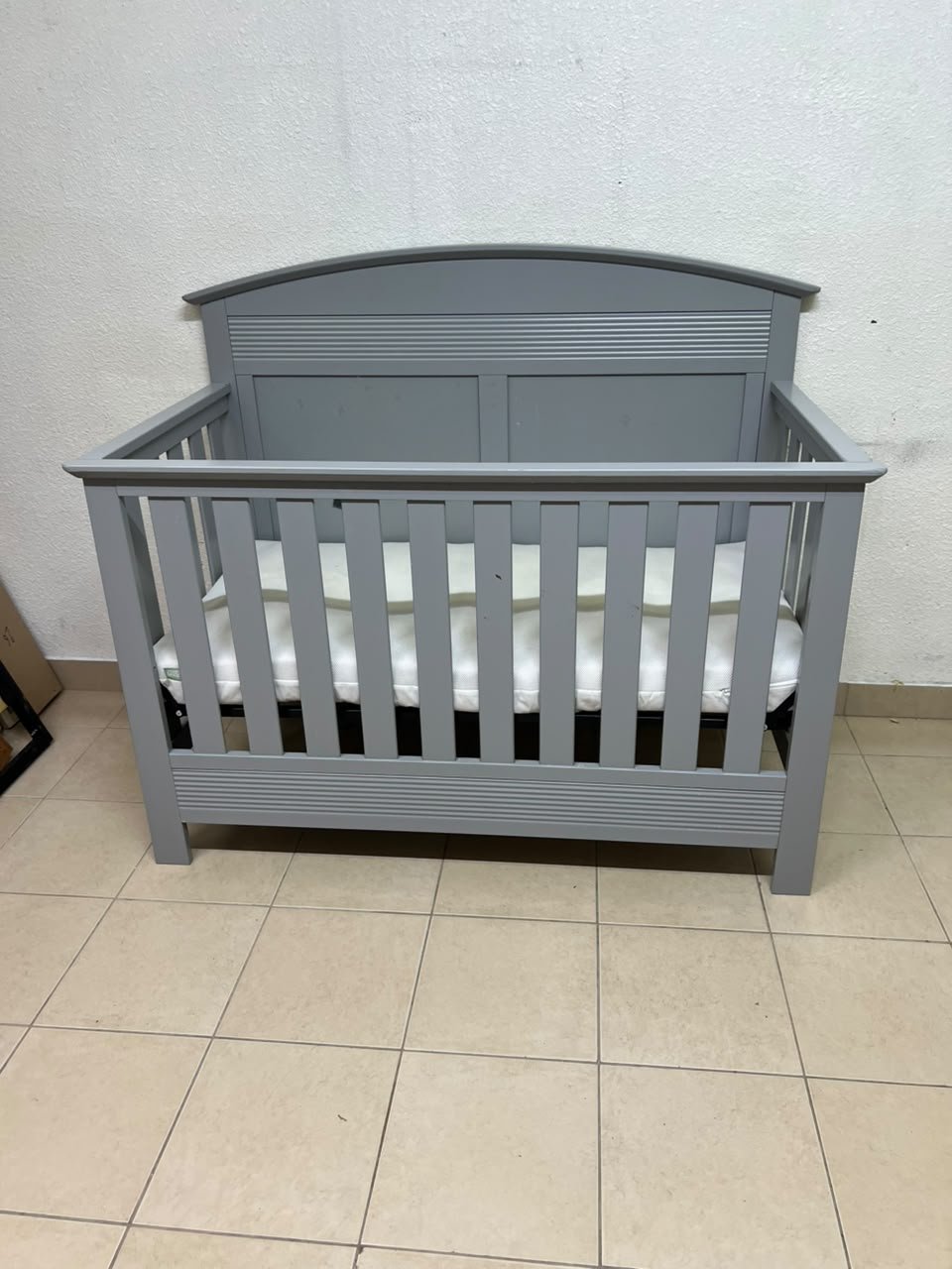 A convertible crib (such as the Serta Barrett model or the Dylan crib by Juniors, available at Centrepoint UAE) in an elegant gray color, featuring a classic, adjustable design that adapts to the various stages of a child's growth. - Image 2