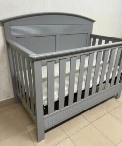 A convertible crib (such as the Serta Barrett model or the Dylan crib by Juniors, available at Centrepoint UAE) in an elegant gray color, featuring a classic, adjustable design that adapts to the various stages of a child's growth. - Image 3