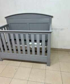 A convertible crib (such as the Serta Barrett model or the Dylan crib by Juniors, available at Centrepoint UAE) in an elegant gray color, featuring a classic, adjustable design that adapts to the various stages of a child's growth. - Image 4