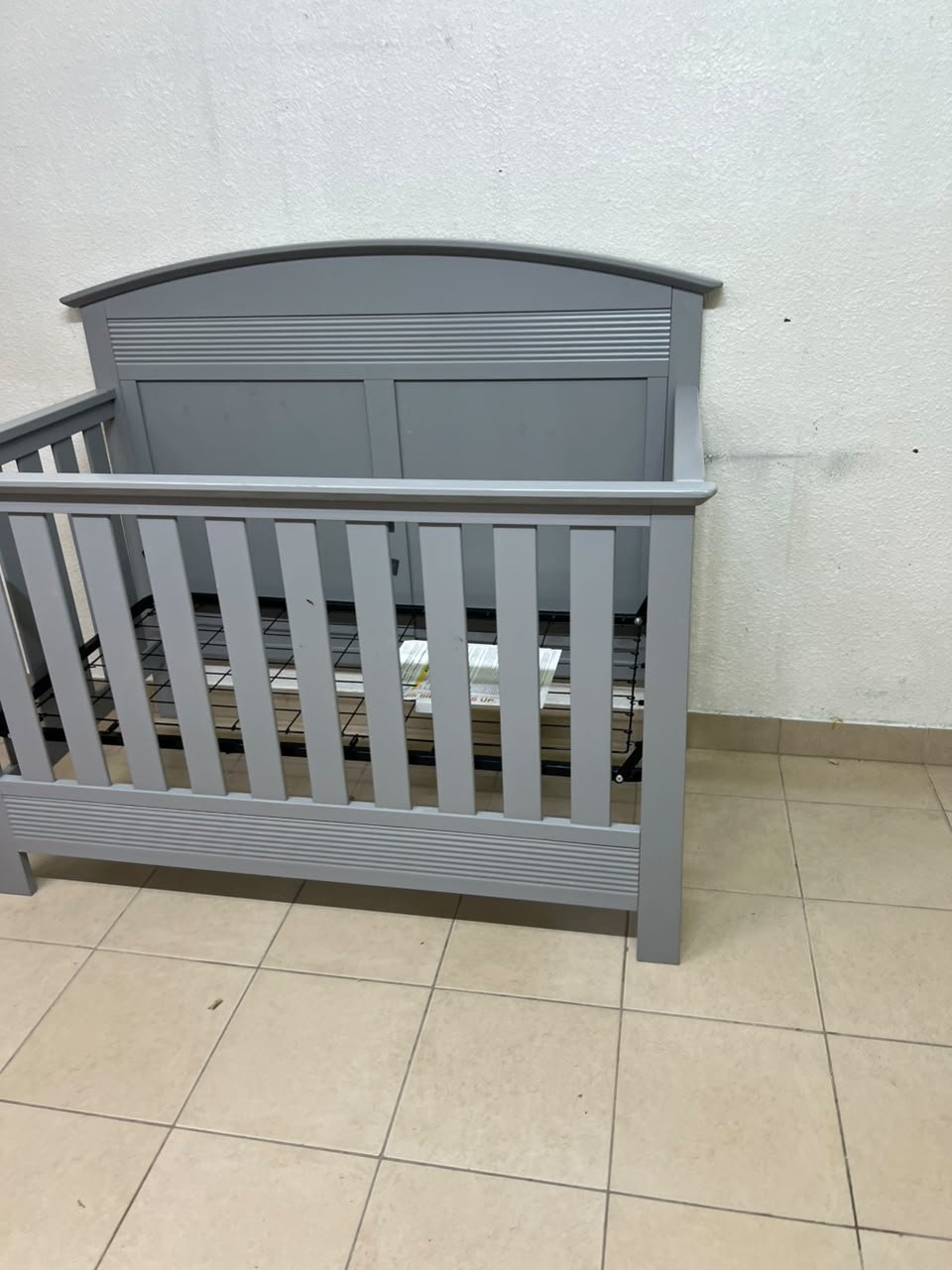 A convertible crib (such as the Serta Barrett model or the Dylan crib by Juniors, available at Centrepoint UAE) in an elegant gray color, featuring a classic, adjustable design that adapts to the various stages of a child's growth. - Image 4