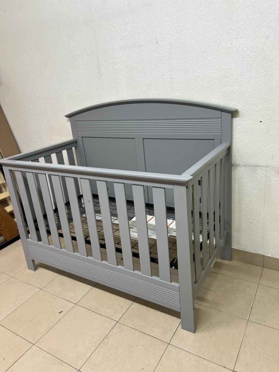 A convertible crib (such as the Serta Barrett model or the Dylan crib by Juniors, available at Centrepoint UAE) in an elegant gray color, featuring a classic, adjustable design that adapts to the various stages of a child's growth. - Image 6