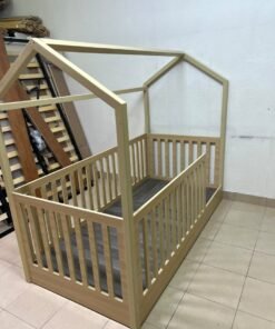 A wooden Montessori house bed—a floor-level or low-profile bed featuring side guardrails—designed to ensure safety while fostering the child's freedom of movement and independence. - Image 9