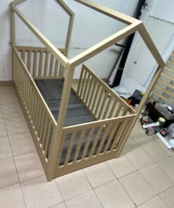 A wooden Montessori house bed—a floor-level or low-profile bed featuring side guardrails—designed to ensure safety while fostering the child's freedom of movement and independence. - Image 10