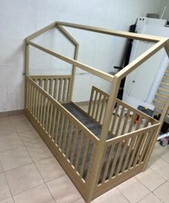 A wooden Montessori house bed—a floor-level or low-profile bed featuring side guardrails—designed to ensure safety while fostering the child's freedom of movement and independence. - Image 4