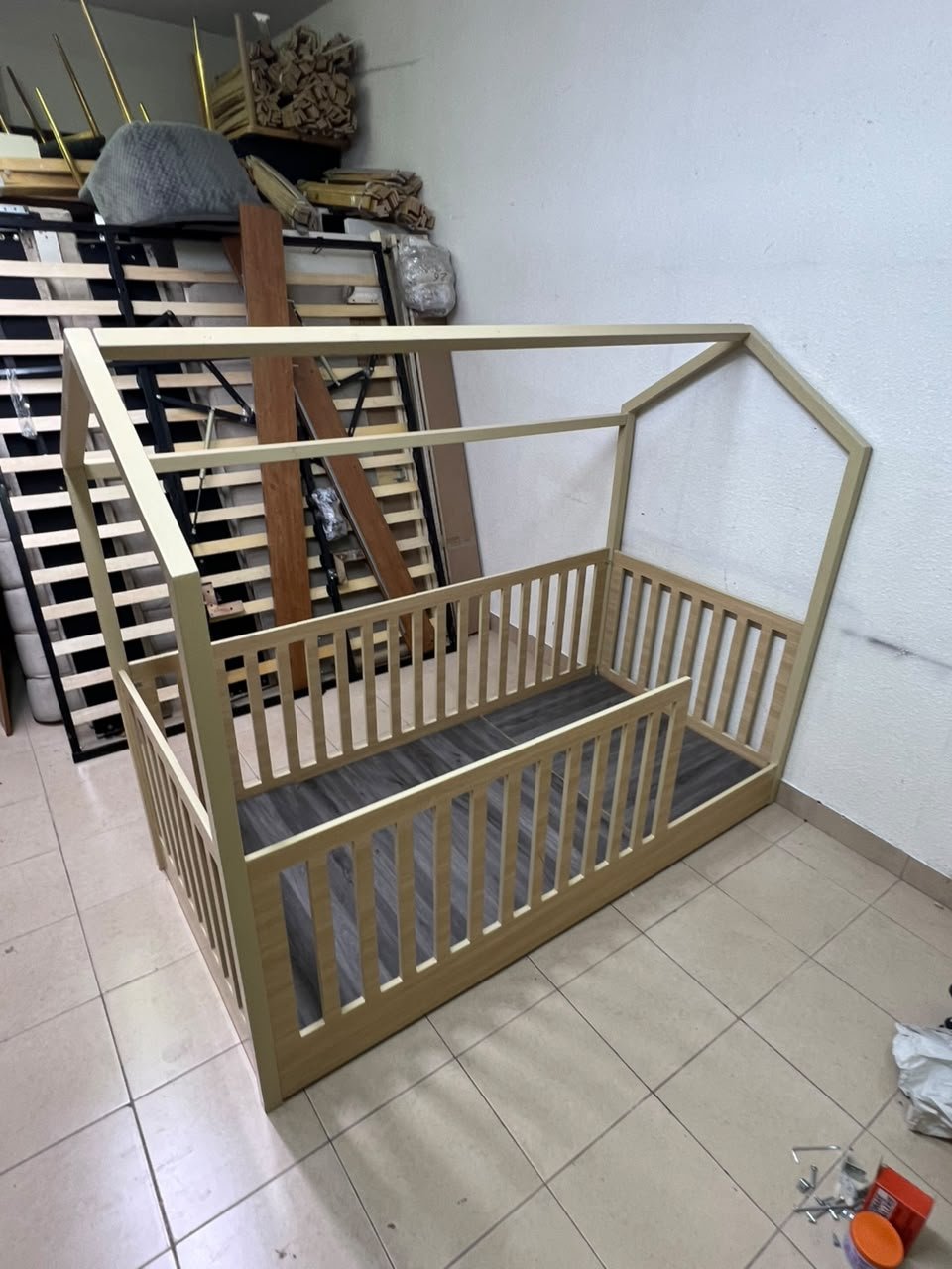 A wooden Montessori house bed—a floor-level or low-profile bed featuring side guardrails—designed to ensure safety while fostering the child's freedom of movement and independence. - Image 8