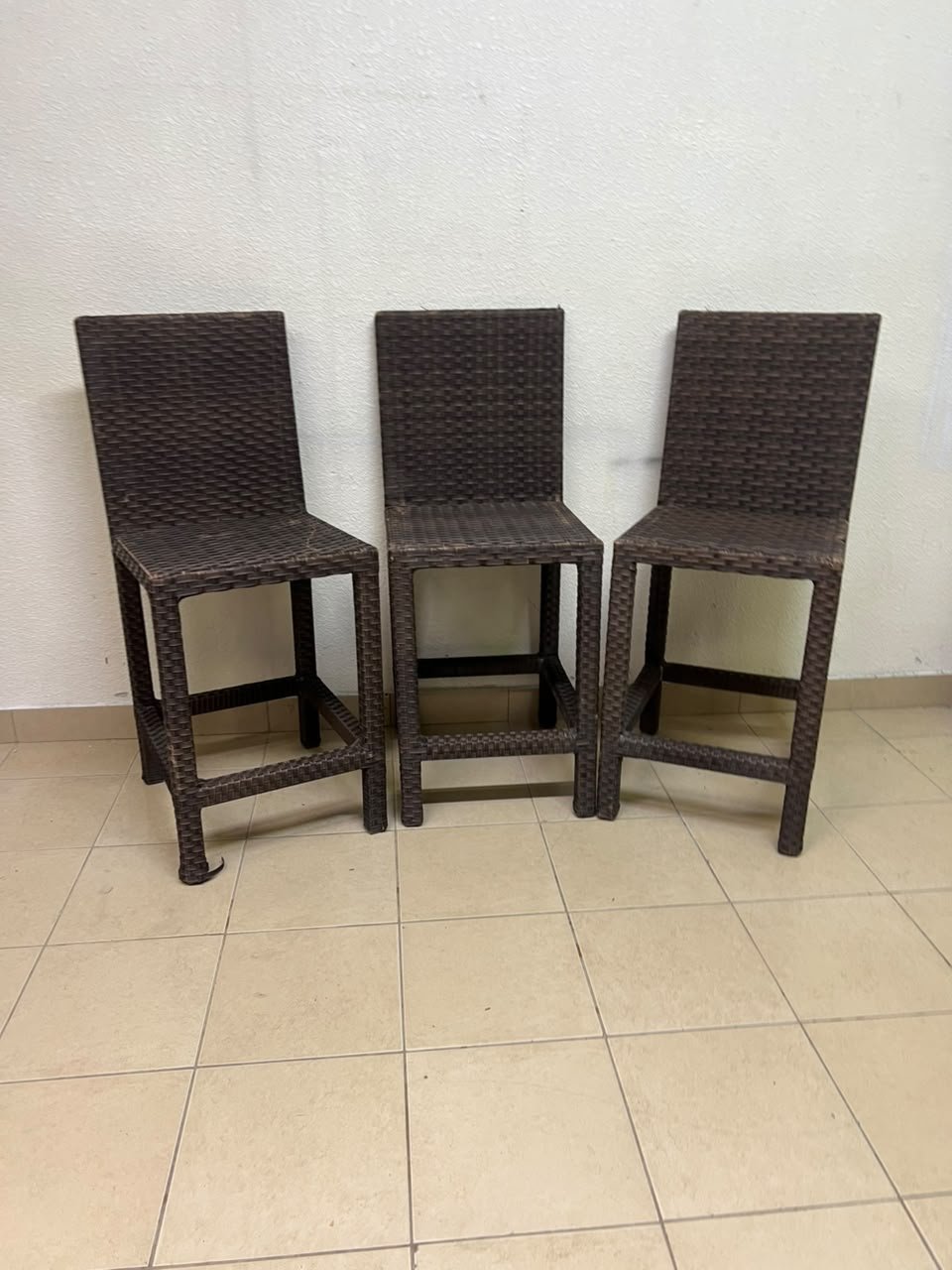 High bar stools made of synthetic rattan (with a woven waist design) in a dark brown color, featuring a high backrest.