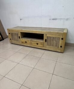 The TV stand shown in the image—a "Band TV" unit—is crafted from natural wood and features an industrial-style design. It includes two side doors, an open shelf in the center, and two small drawers at the bottom.