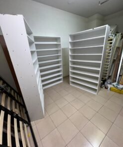 Three white open shelving/display units, constructed from wood, melamine, or MDF, featuring multi-level shelves. - Image 2