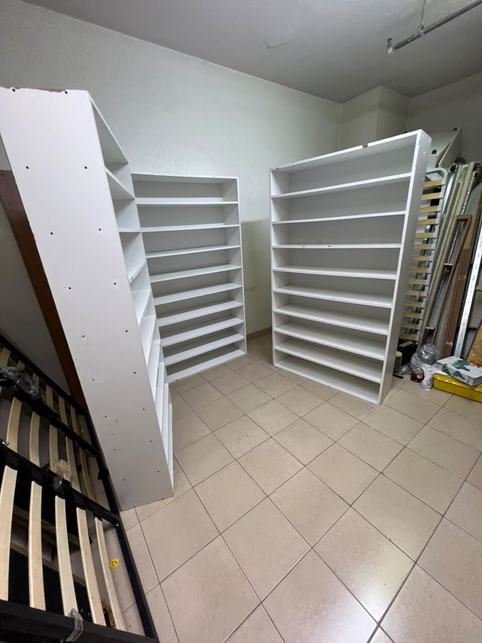 Three white open shelving/display units, constructed from wood, melamine, or MDF, featuring multi-level shelves. - Image 2