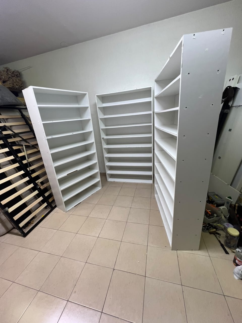 Three white open shelving/display units, constructed from wood, melamine, or MDF, featuring multi-level shelves. - Image 3