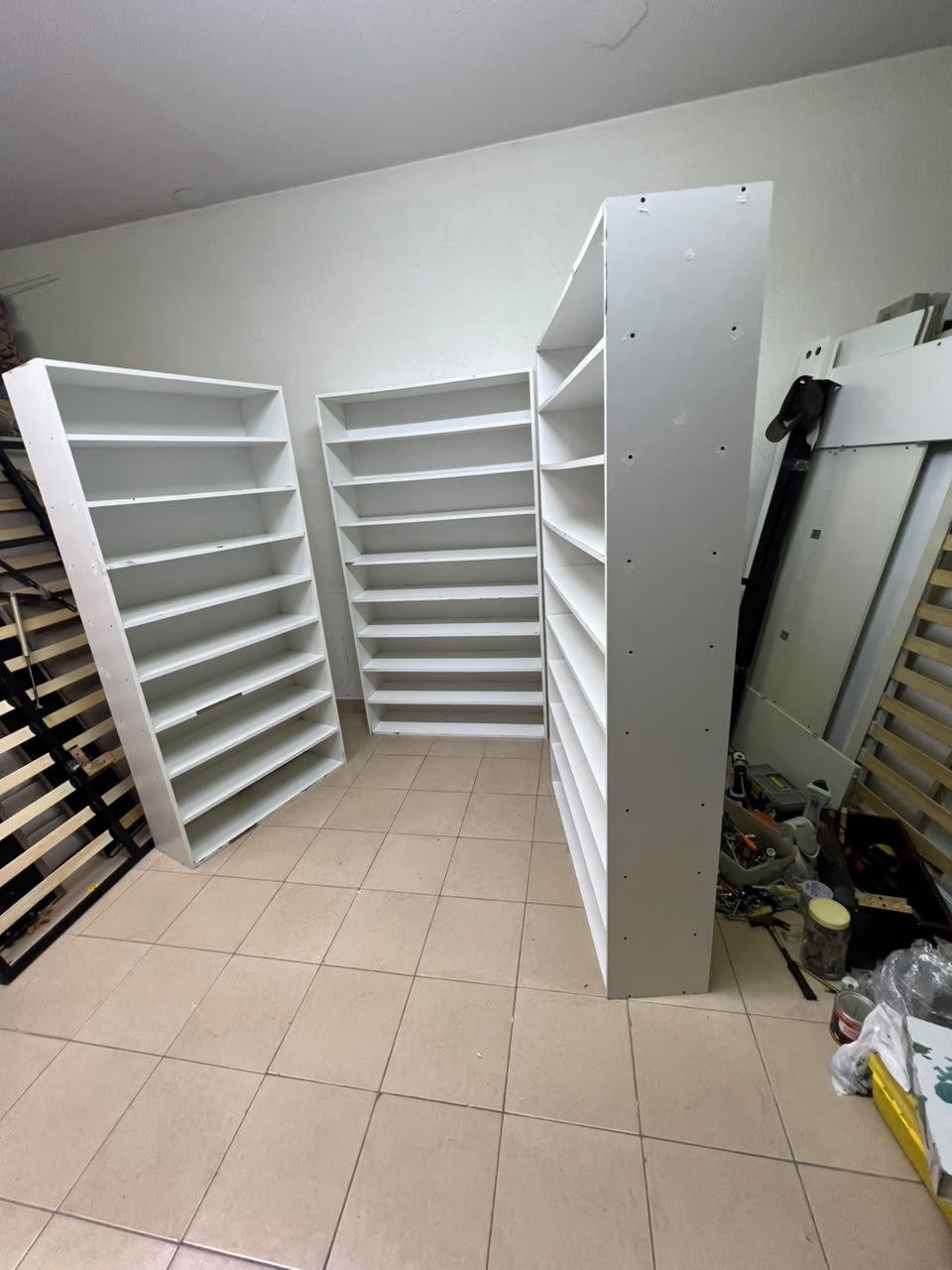 Three white open shelving/display units, constructed from wood, melamine, or MDF, featuring multi-level shelves. - Image 8