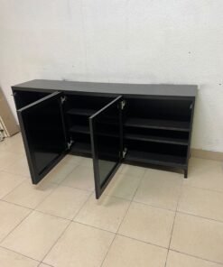 A cabinet (such as a TV stand or sideboard) that appears as a glossy black storage unit with three doors and slender legs; it bears a strong resemblance to the IKEA BESTÅ collection (specifically the Selsviken/Stubbarp combination in black-brown with high-gloss doors). - Image 9