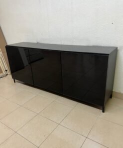 A cabinet (such as a TV stand or sideboard) that appears as a glossy black storage unit with three doors and slender legs; it bears a strong resemblance to the IKEA BESTÅ collection (specifically the Selsviken/Stubbarp combination in black-brown with high-gloss doors). - Image 11