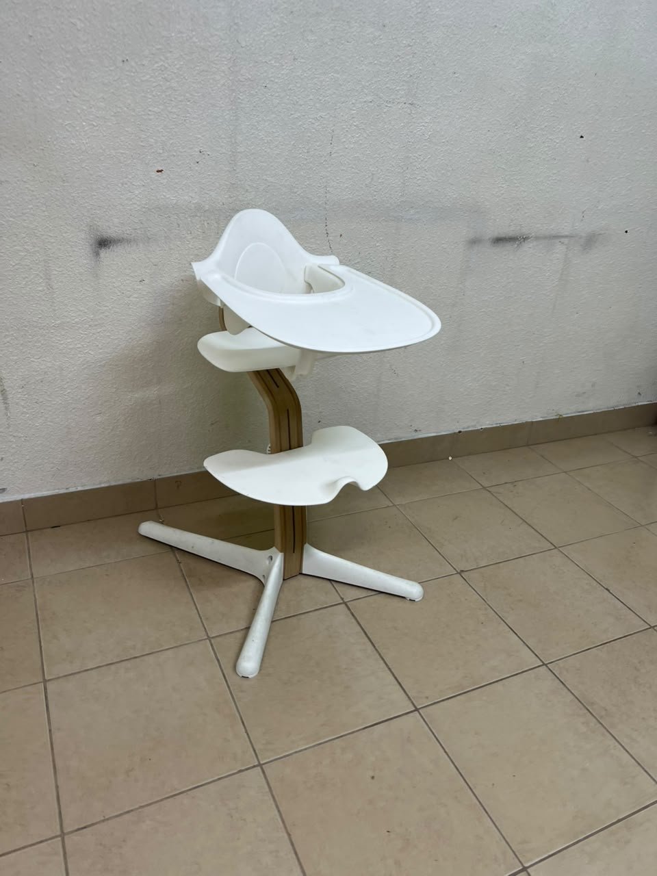 Stokke Nomi High Chair in white, complete with a Baby Set and a tray.