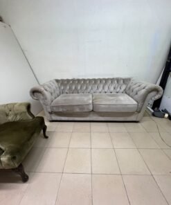 Classic Chesterfield-style furniture upholstered in velvet, featuring a long grey or silver sofa with a button-tufted backrest, accompanied by a matching armchair (fauteuil) in a dark green or olive shade, sharing the same plush, classic design. - Image 3