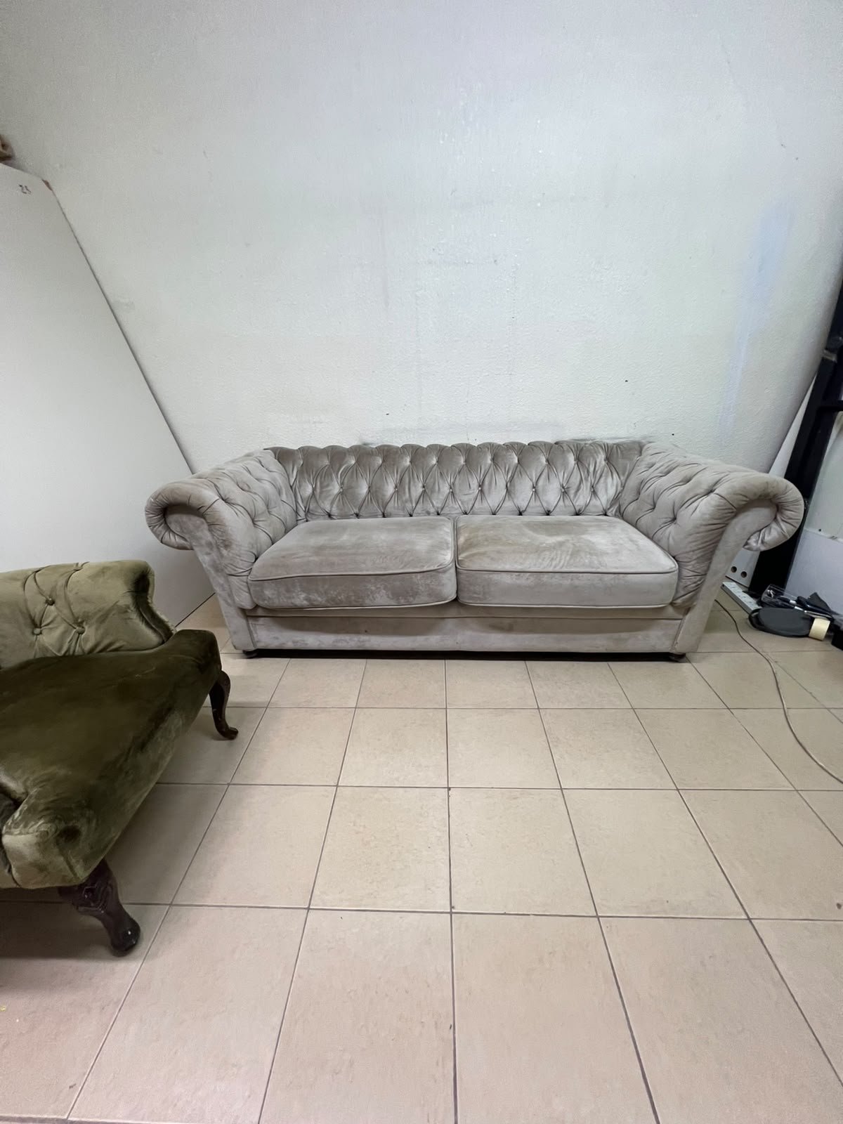 Classic Chesterfield-style furniture upholstered in velvet, featuring a long grey or silver sofa with a button-tufted backrest, accompanied by a matching armchair (fauteuil) in a dark green or olive shade, sharing the same plush, classic design. - Image 3