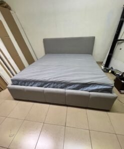 Light gray upholstered bed featuring a high headboard with a vertical channel-tufted design; part of a collection of platform storage beds. - Image 2