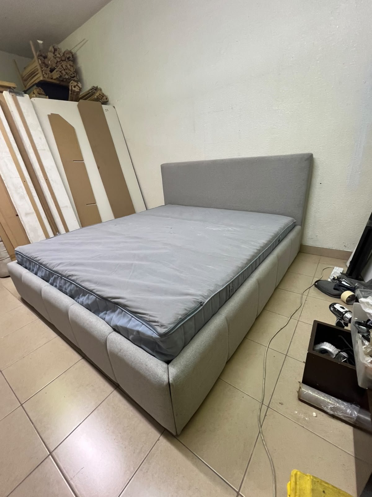 Light gray upholstered bed featuring a high headboard with a vertical channel-tufted design; part of a collection of platform storage beds.