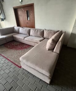 A U-shaped sectional sofa upholstered in beige or light gray fabric, featuring separate backrest cushions and two chaise longue/footrest sections on the sides. - Image 7