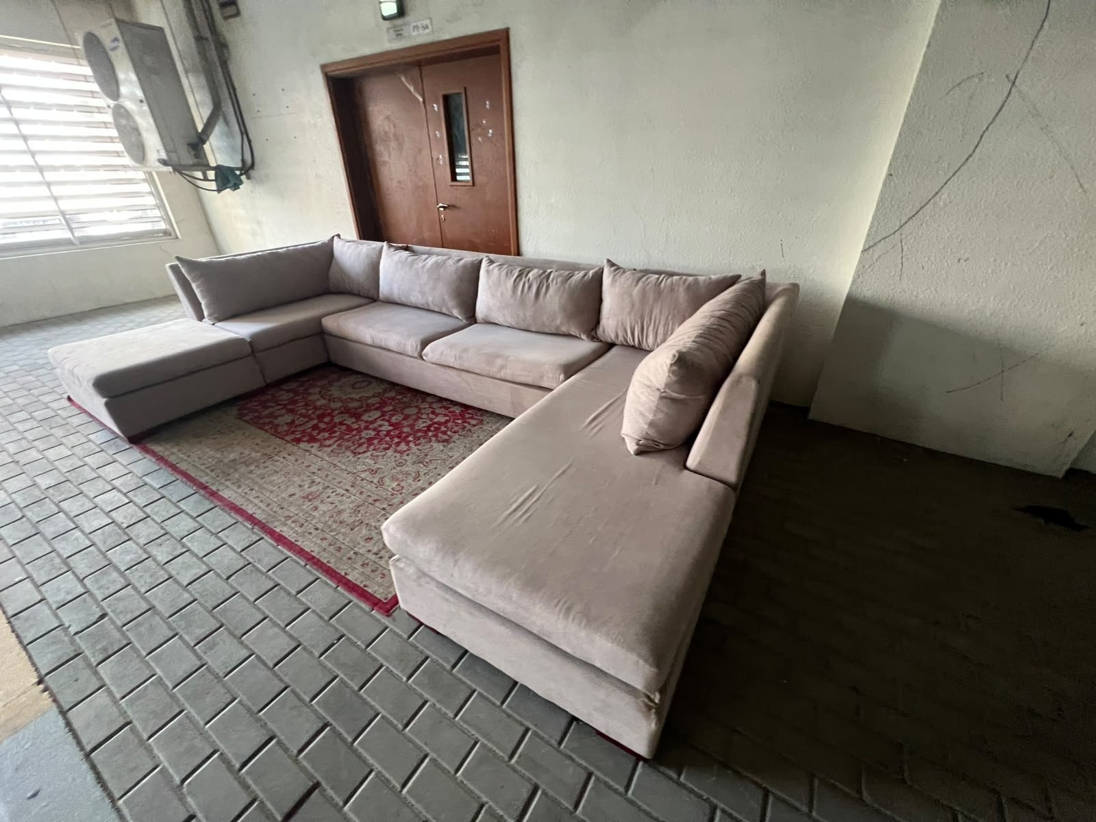 A U-shaped sectional sofa upholstered in beige or light gray fabric, featuring separate backrest cushions and two chaise longue/footrest sections on the sides. - Image 7