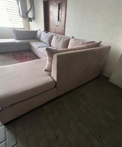 A U-shaped sectional sofa upholstered in beige or light gray fabric, featuring separate backrest cushions and two chaise longue/footrest sections on the sides. - Image 11