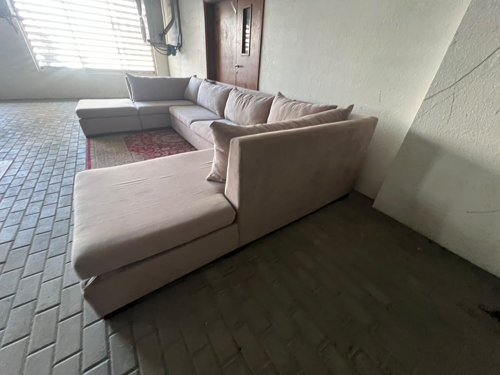 A U-shaped sectional sofa upholstered in beige or light gray fabric, featuring separate backrest cushions and two chaise longue/footrest sections on the sides. - Image 11