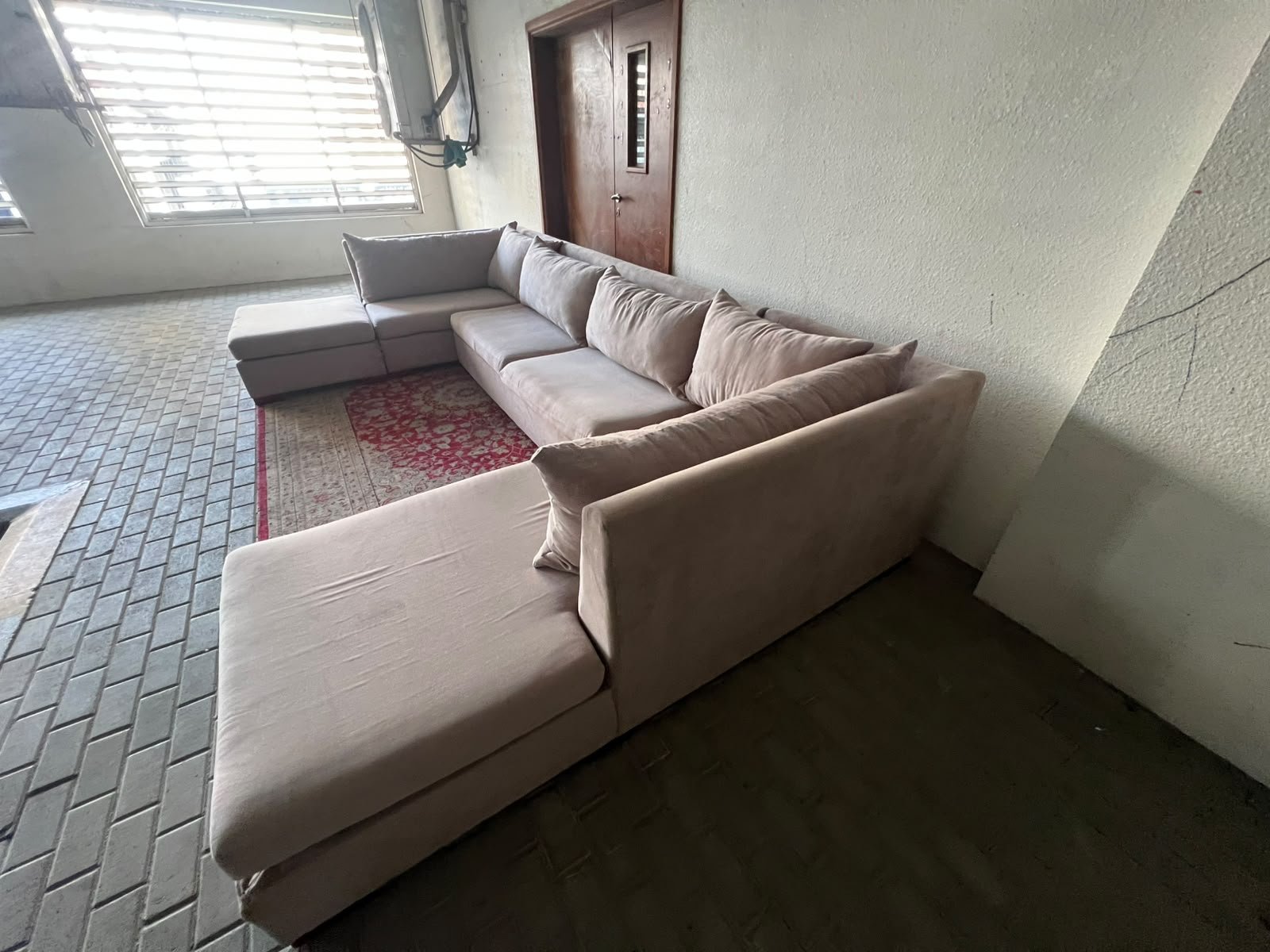 A U-shaped sectional sofa upholstered in beige or light gray fabric, featuring separate backrest cushions and two chaise longue/footrest sections on the sides. - Image 2