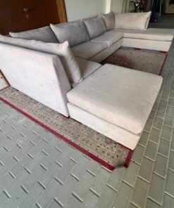 A U-shaped sectional sofa upholstered in beige or light gray fabric, featuring separate backrest cushions and two chaise longue/footrest sections on the sides. - Image 3