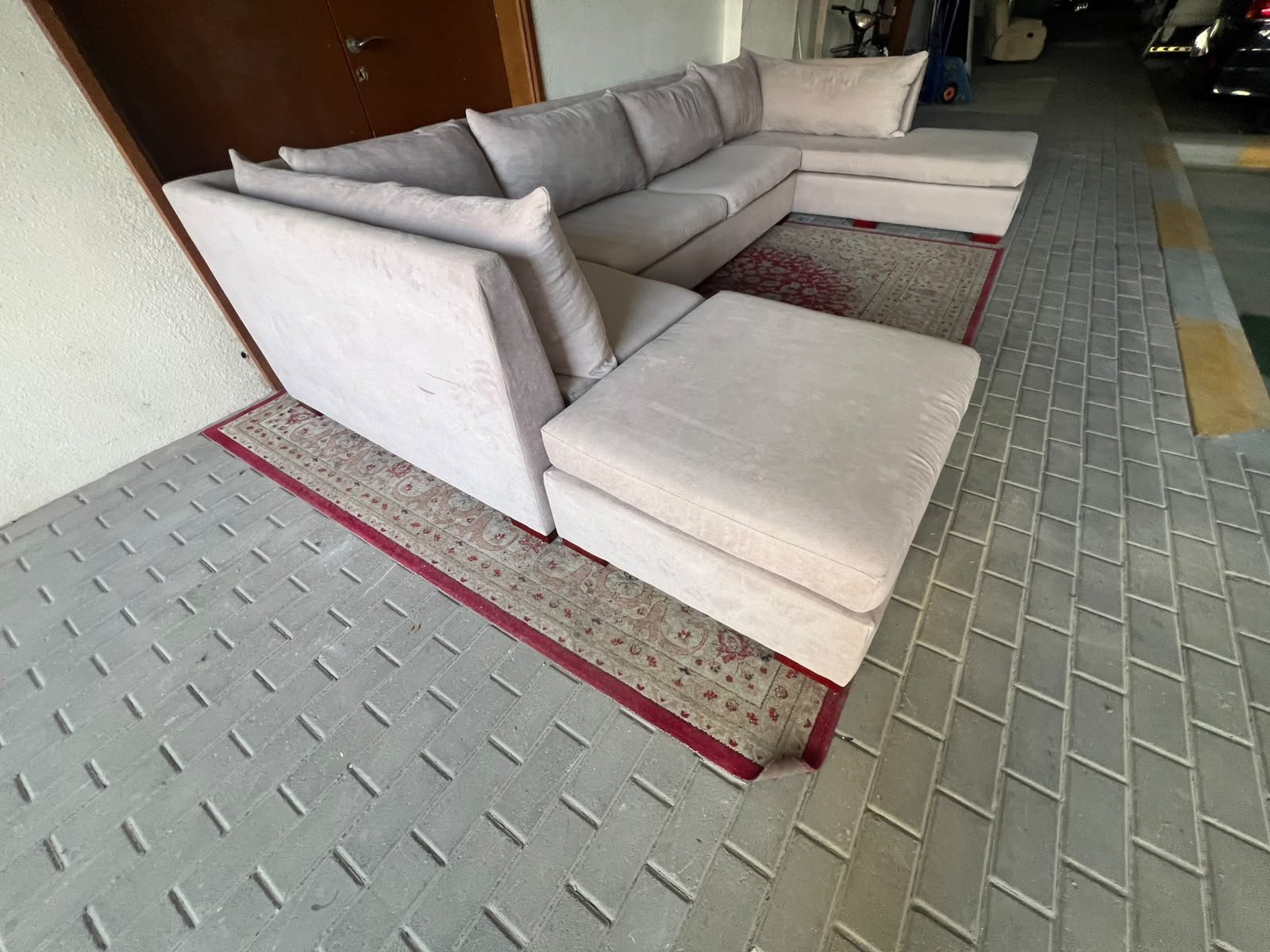 A U-shaped sectional sofa upholstered in beige or light gray fabric, featuring separate backrest cushions and two chaise longue/footrest sections on the sides. - Image 3