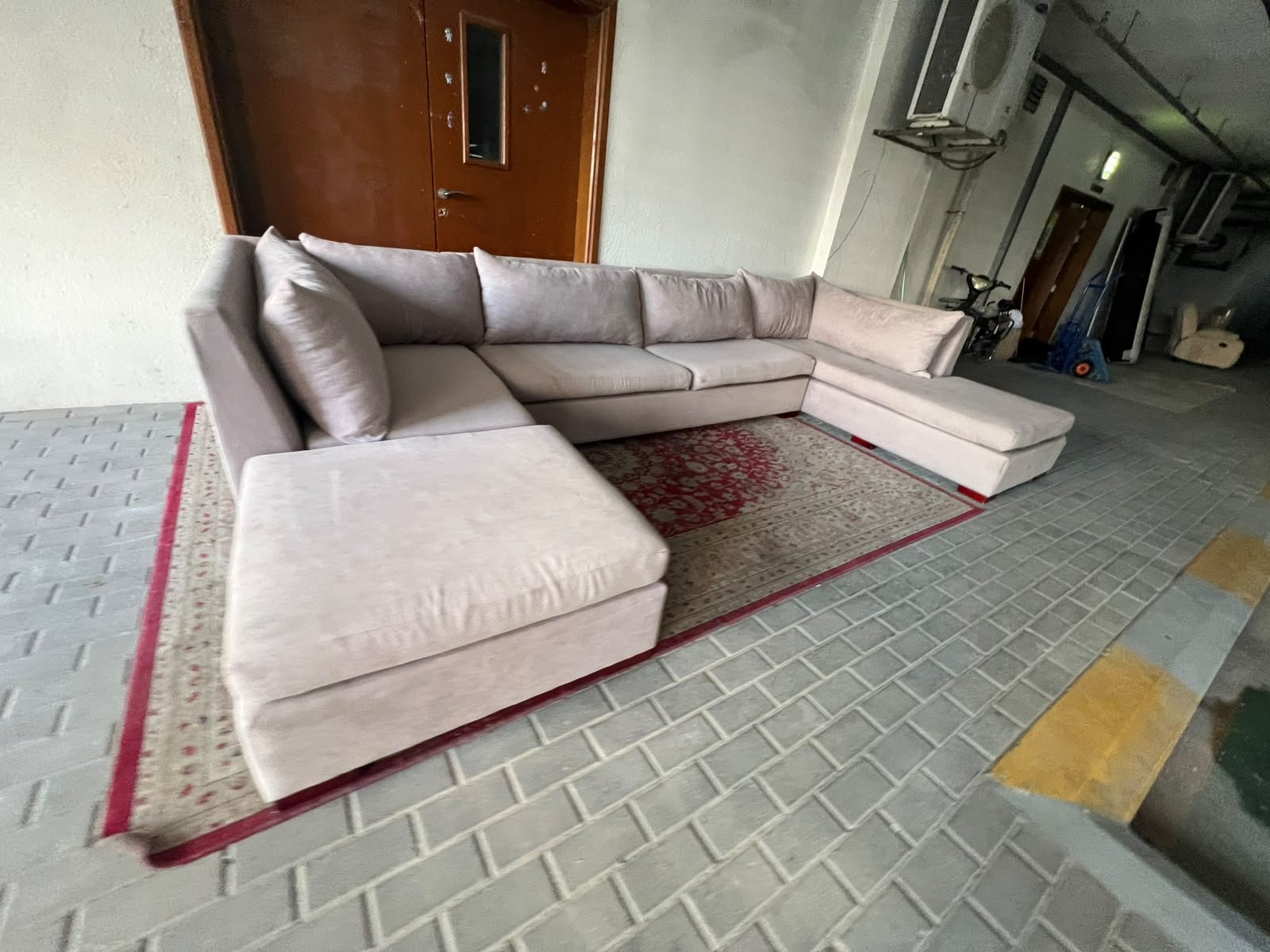 A U-shaped sectional sofa upholstered in beige or light gray fabric, featuring separate backrest cushions and two chaise longue/footrest sections on the sides. - Image 4