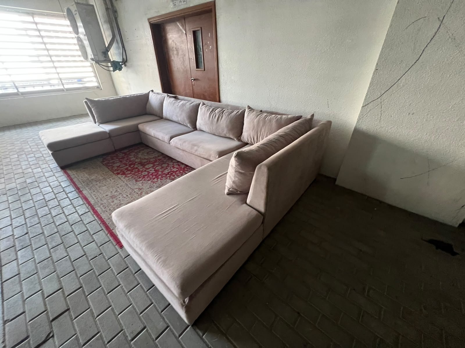 A U-shaped sectional sofa upholstered in beige or light gray fabric, featuring separate backrest cushions and two chaise longue/footrest sections on the sides. - Image 6