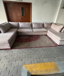 A U-shaped sectional sofa upholstered in beige or light gray fabric, featuring separate backrest cushions and two chaise longue/footrest sections on the sides. - Image 8