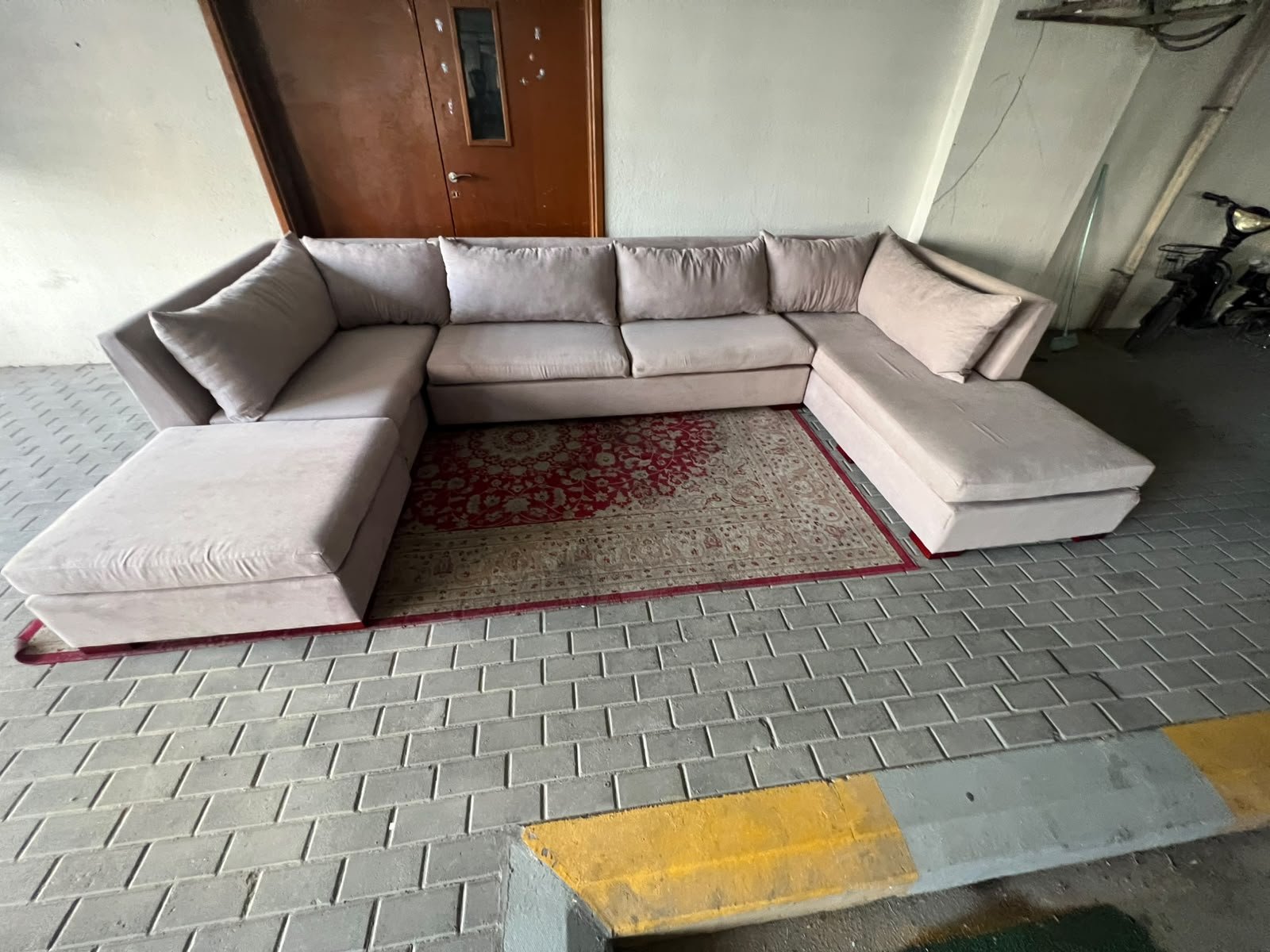 A U-shaped sectional sofa upholstered in beige or light gray fabric, featuring separate backrest cushions and two chaise longue/footrest sections on the sides. - Image 10